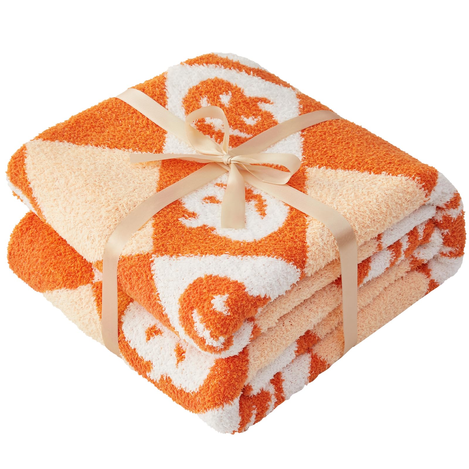 Folded orange patterned Halloween blanket with a ribbon on a white background