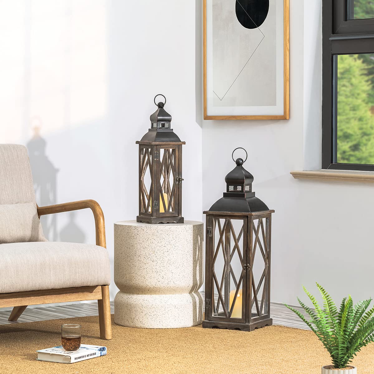 Two decorative lanterns on a side table in a room with a chair and plant.