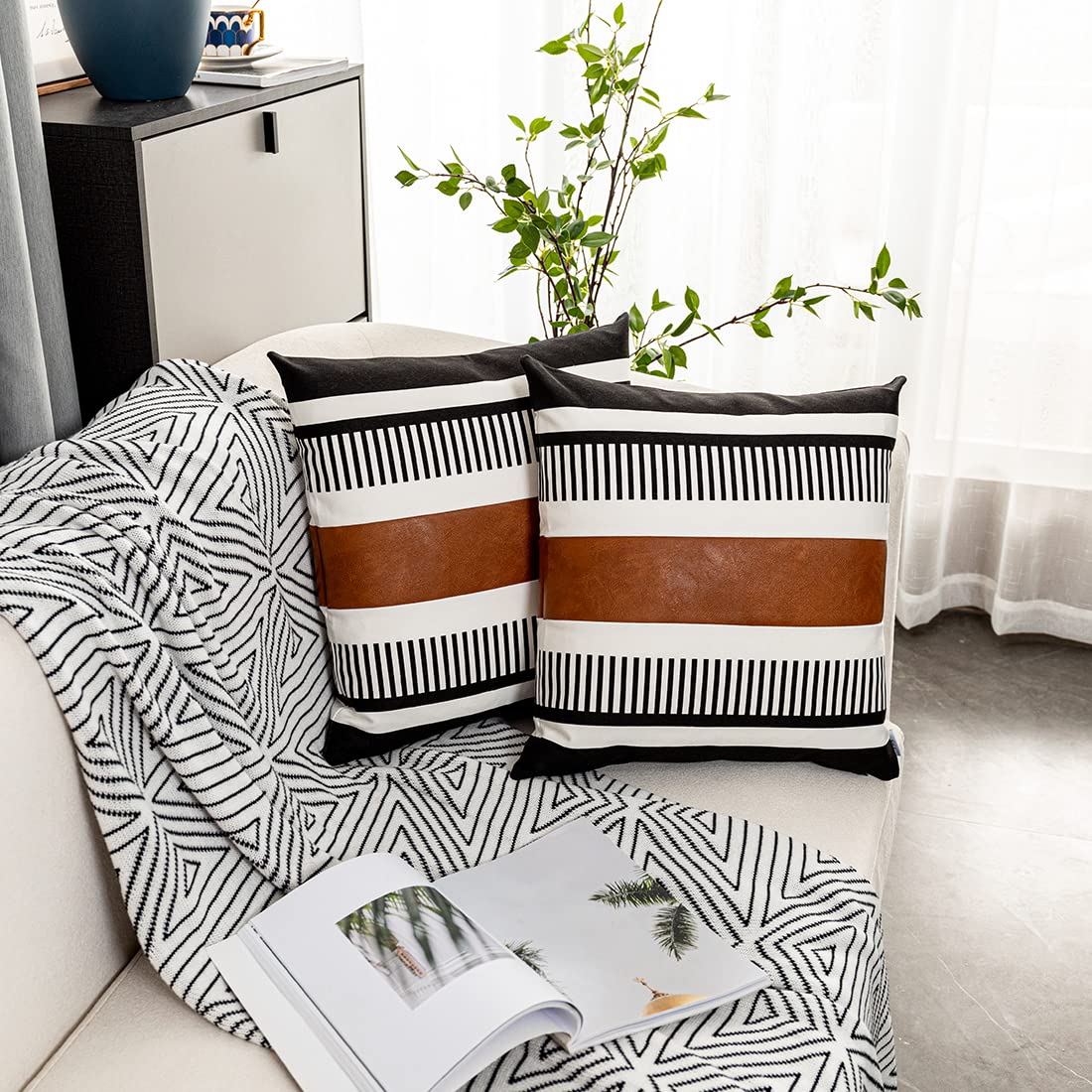 Set of 2 pillow covers with black and white striped pattern and brown faux leather accent