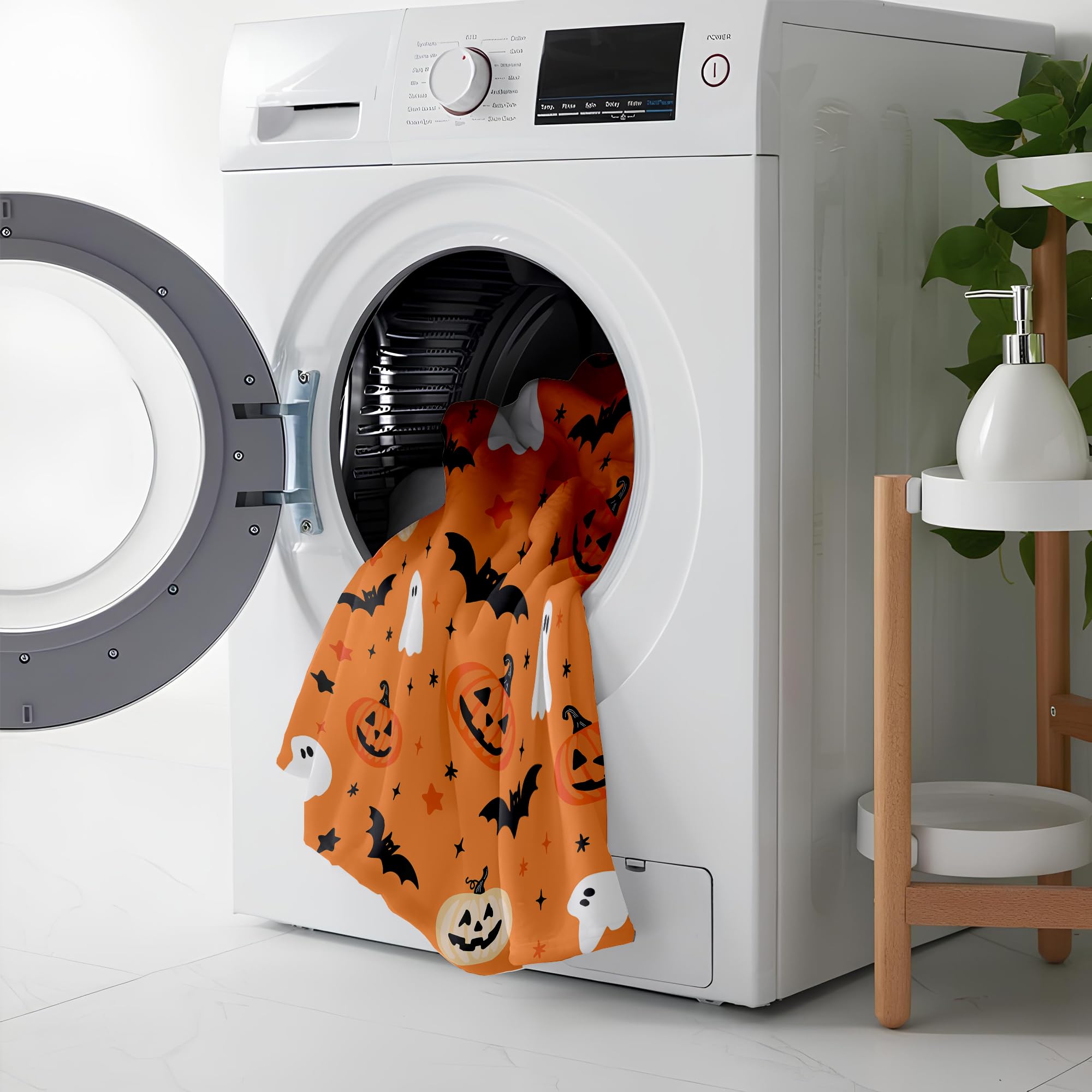 White washing machine with Halloween-themed blanket showing machine washable.