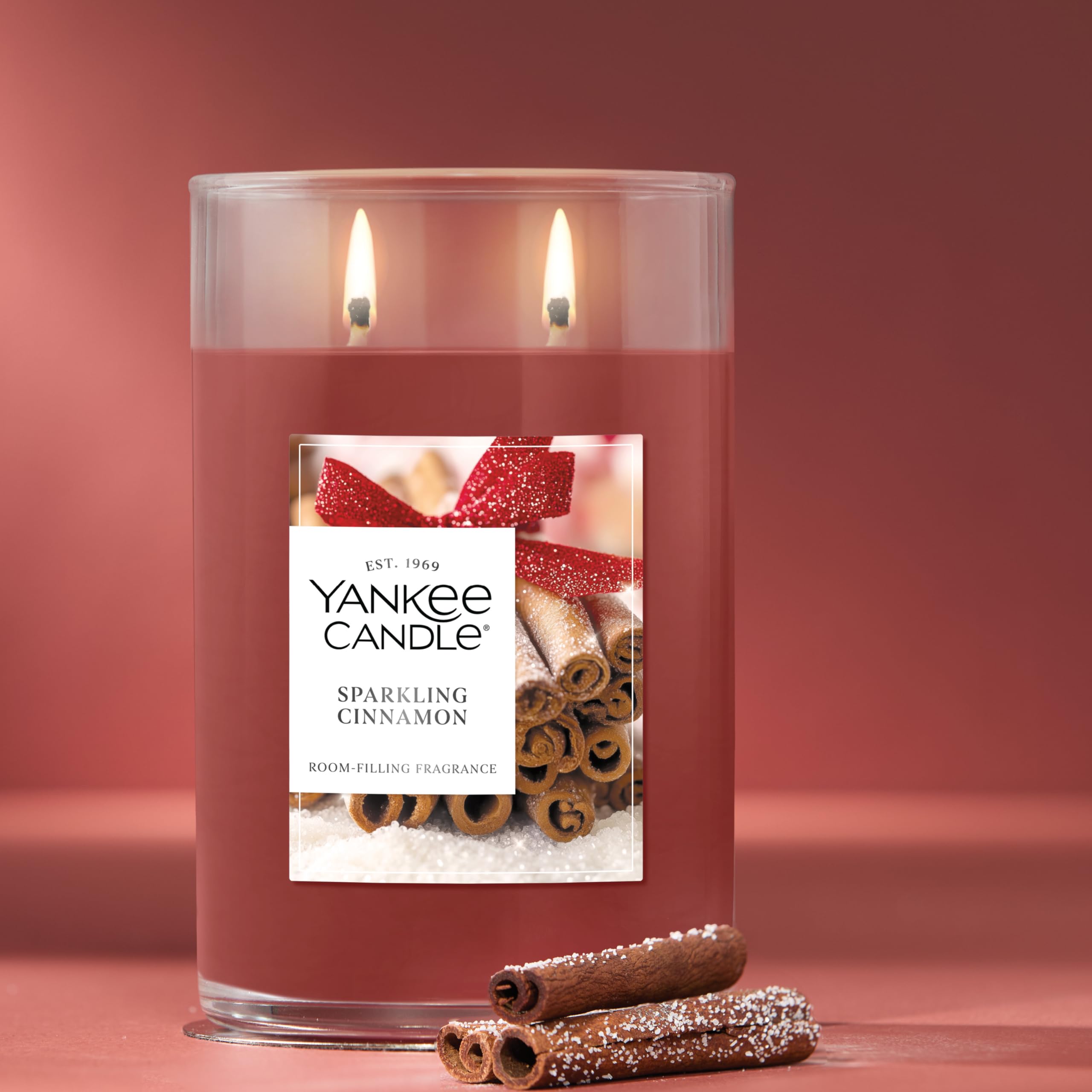 Yankee Candle sparkling cinnamon candle with cinnamon sticks on a red background