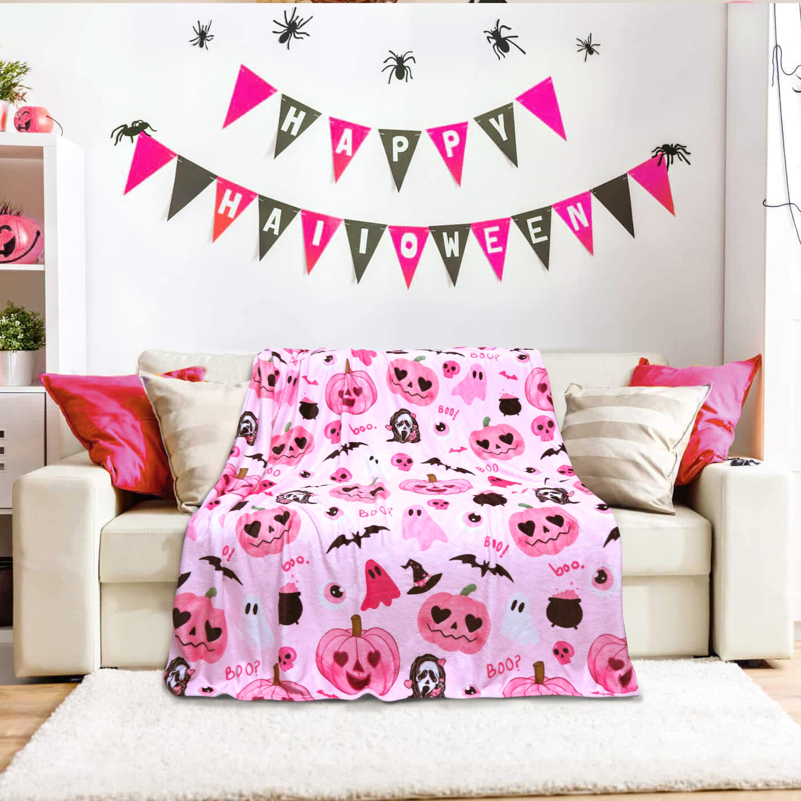 Pink Halloween blanket on a couch with 'Happy Halloween' banner above