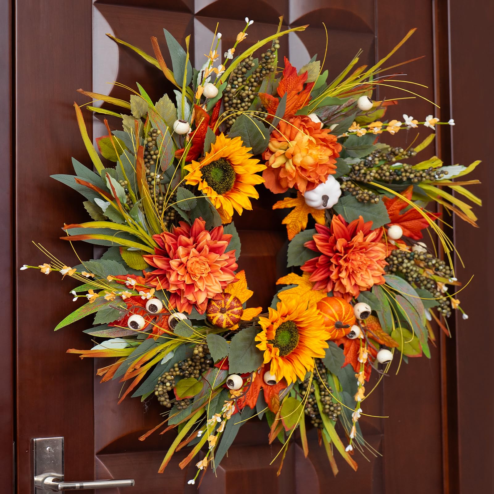 Autumn-themed wreath with flowers and leaves on a wooden door