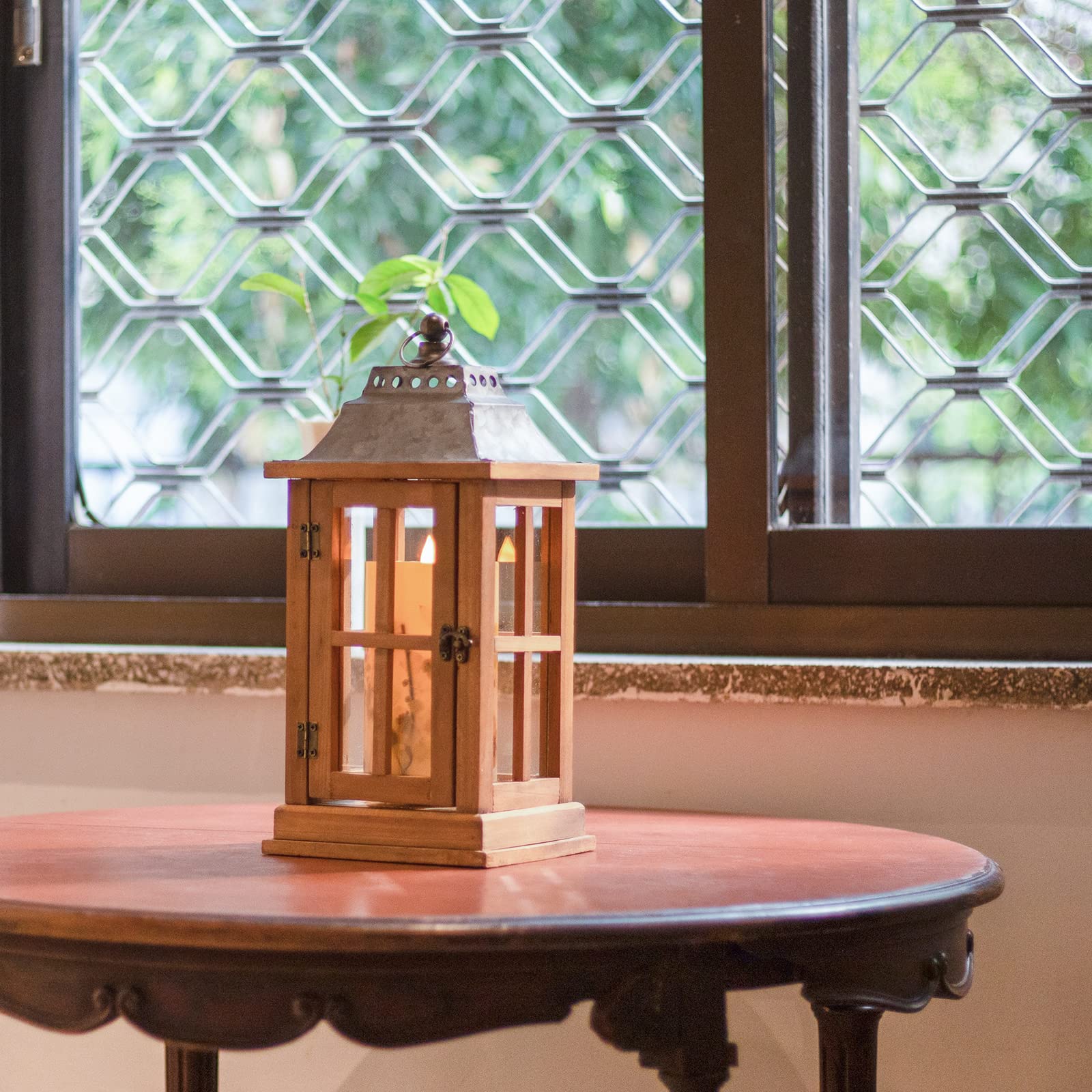 Wooden lantern on a table with a window in the background