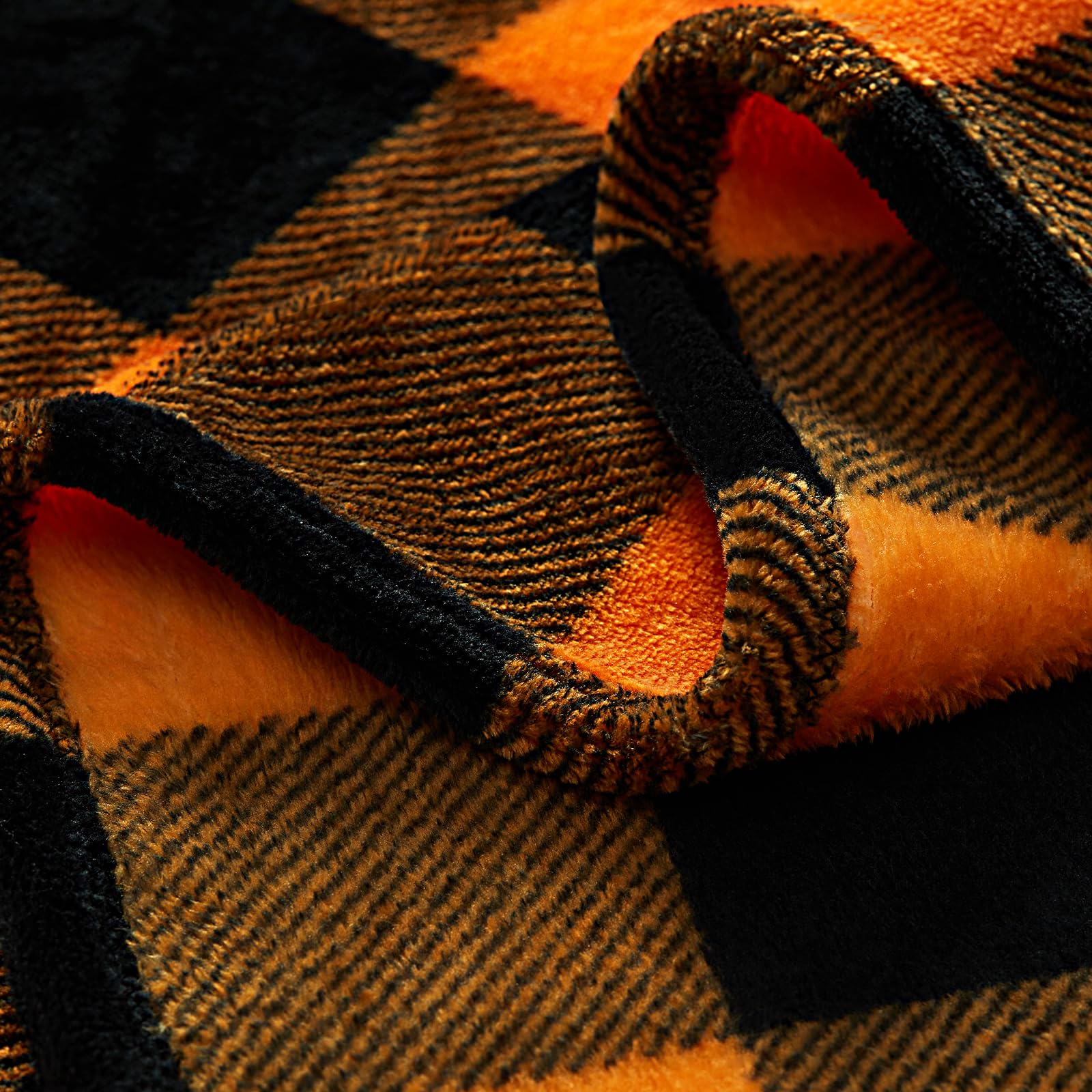 Close-up of a Halloween orange and black checkered blanket fabric.