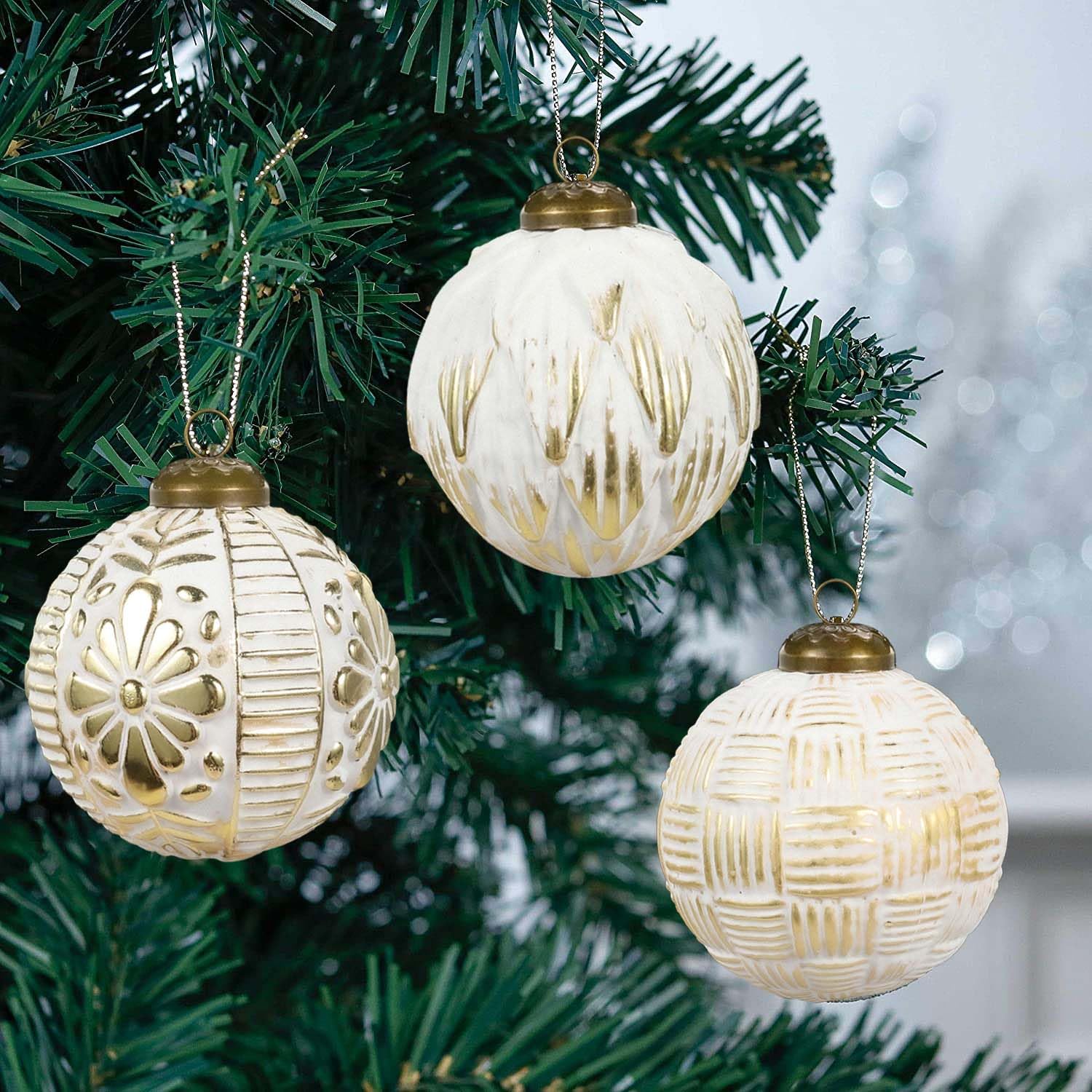 hanging shiny ornaments on fake Christmas tree
