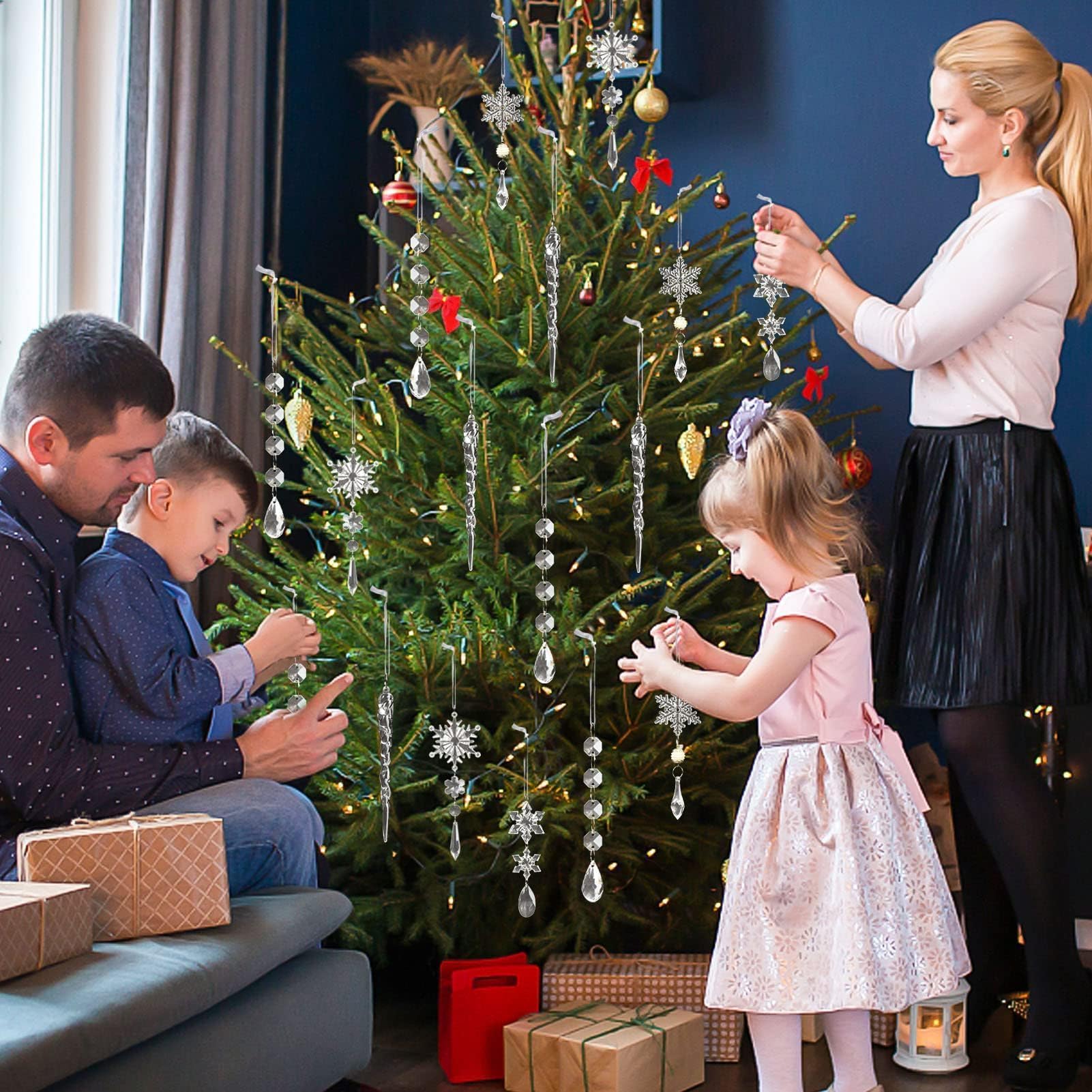family hanging crystal ornaments on Christmas tree