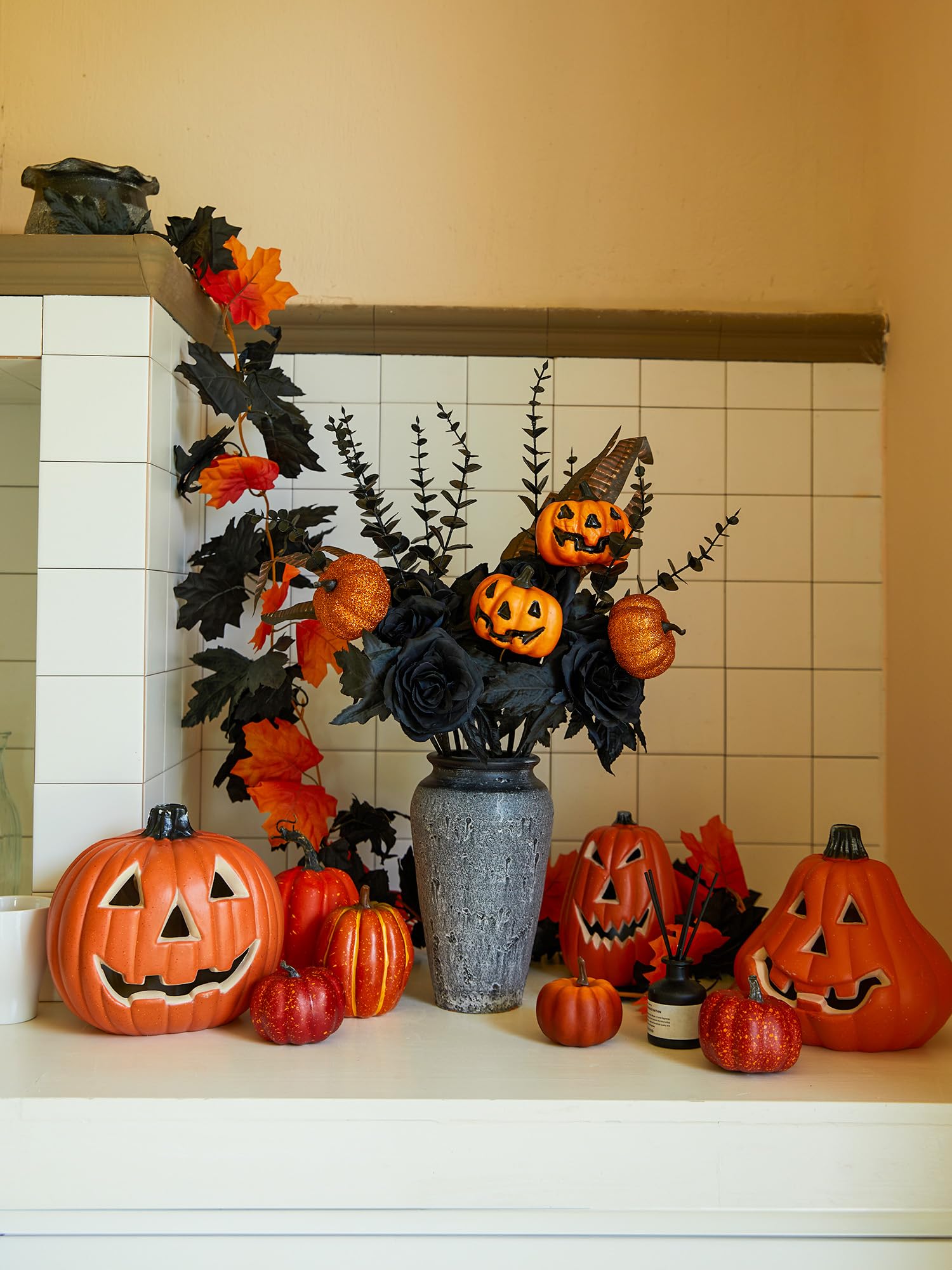Shiny black roses and pumpkins in porcelain vase