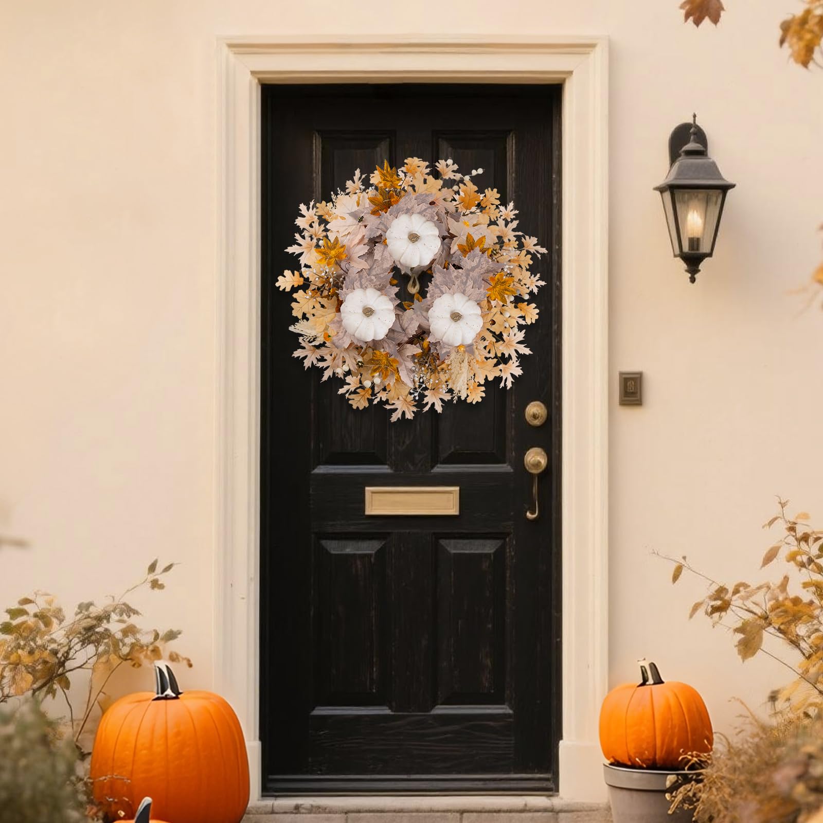 Decorative fall wreath on a black door with pumpkins
