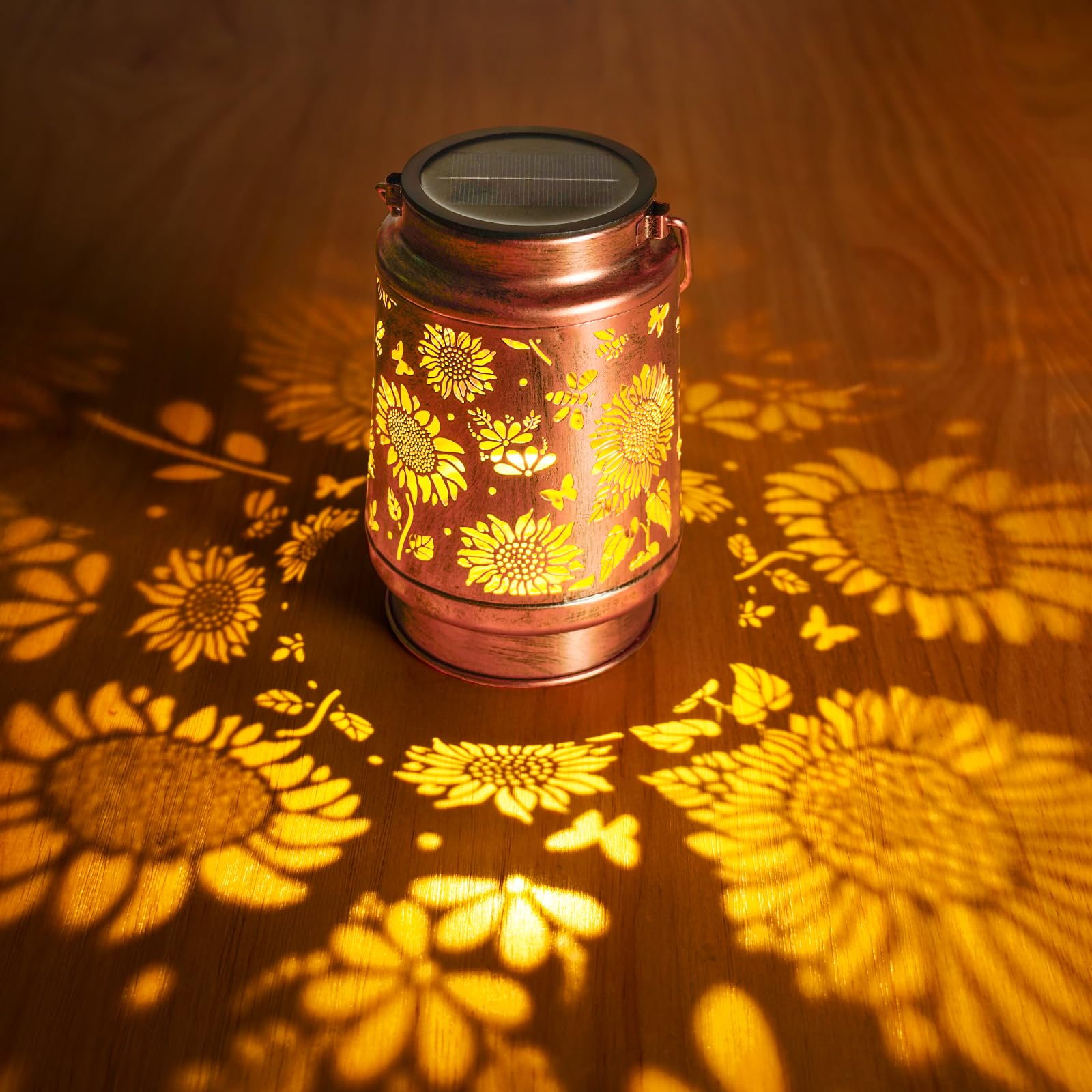 Decorative lantern with sunflower pattern casting shadows on a wooden surface