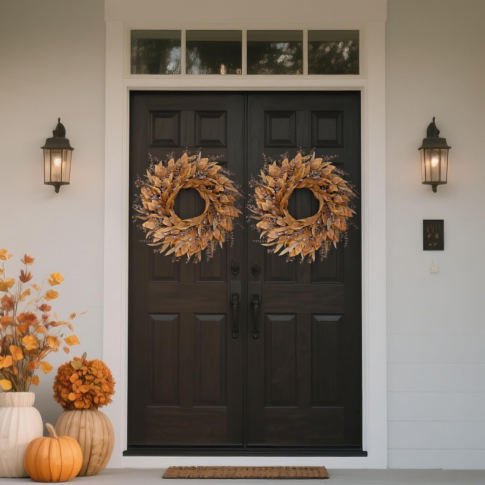 Black double door with autumn wreaths, pumpkins, and decorative plants.