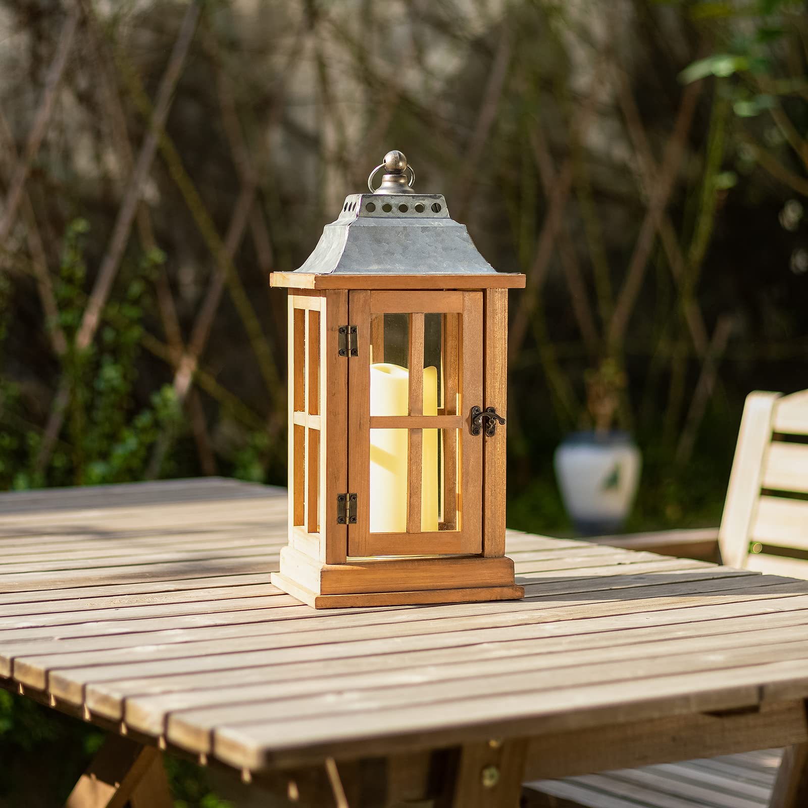 Wooden lantern with a candle on a wooden table outdoors