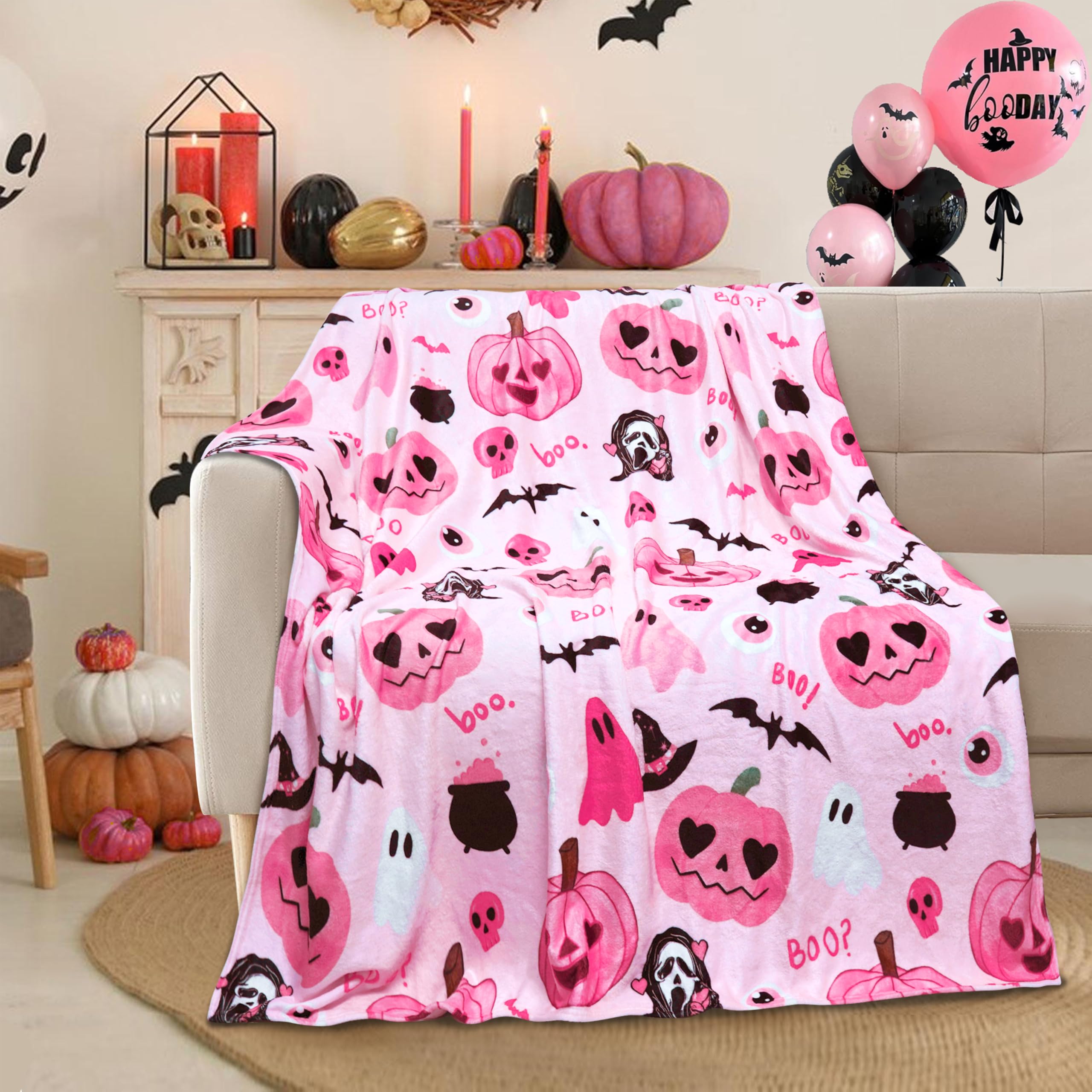 Pink Halloween-themed blanket draped over a chair with pumpkins and decorations in the background.
