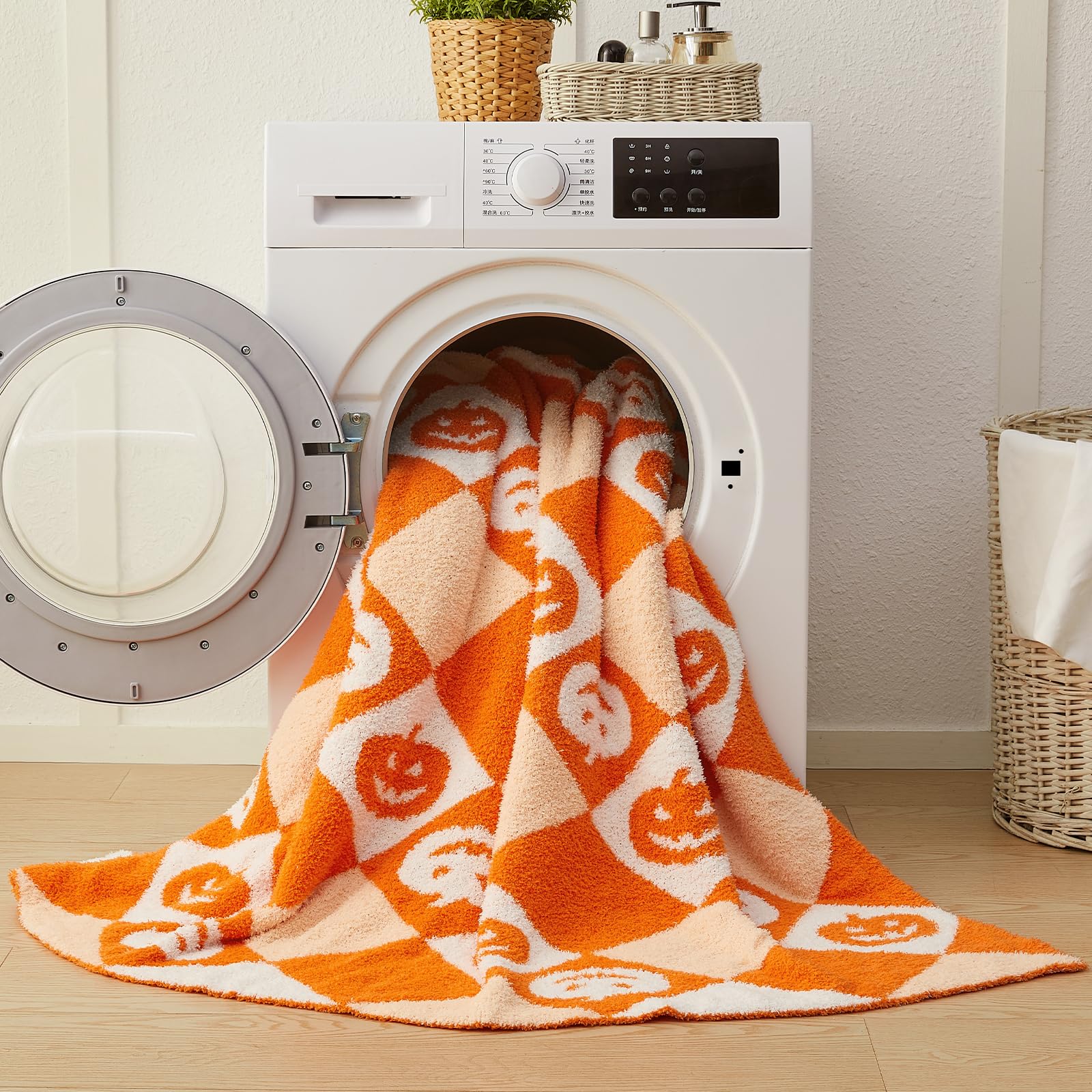 Orange and white patterned Halloween blanket draped over a washing machine in a laundry room.
