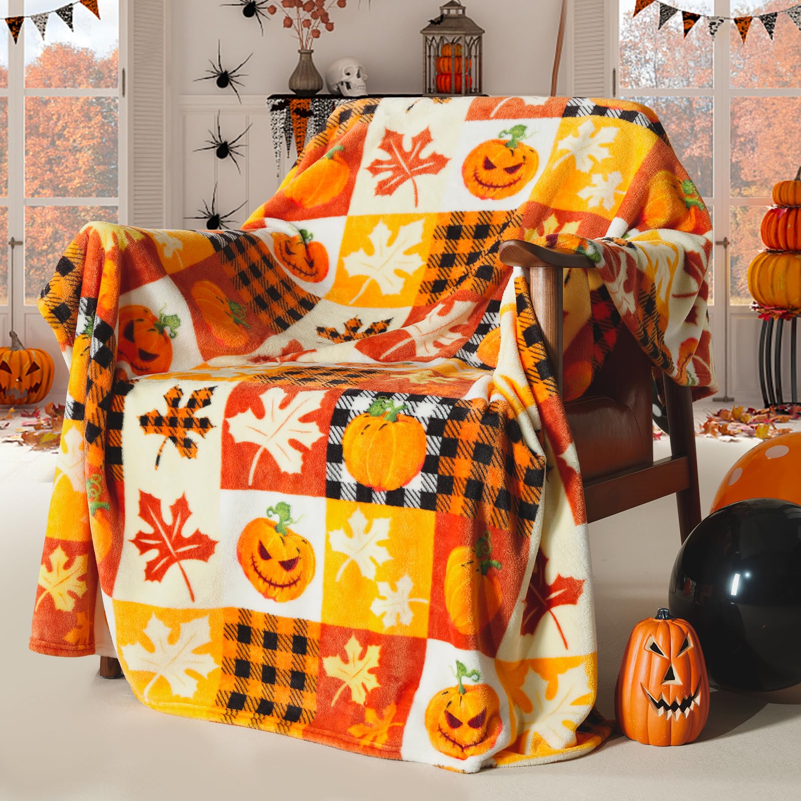 Halloween-themed blanket with pumpkins and leaves draped over a chair in a decorated room.