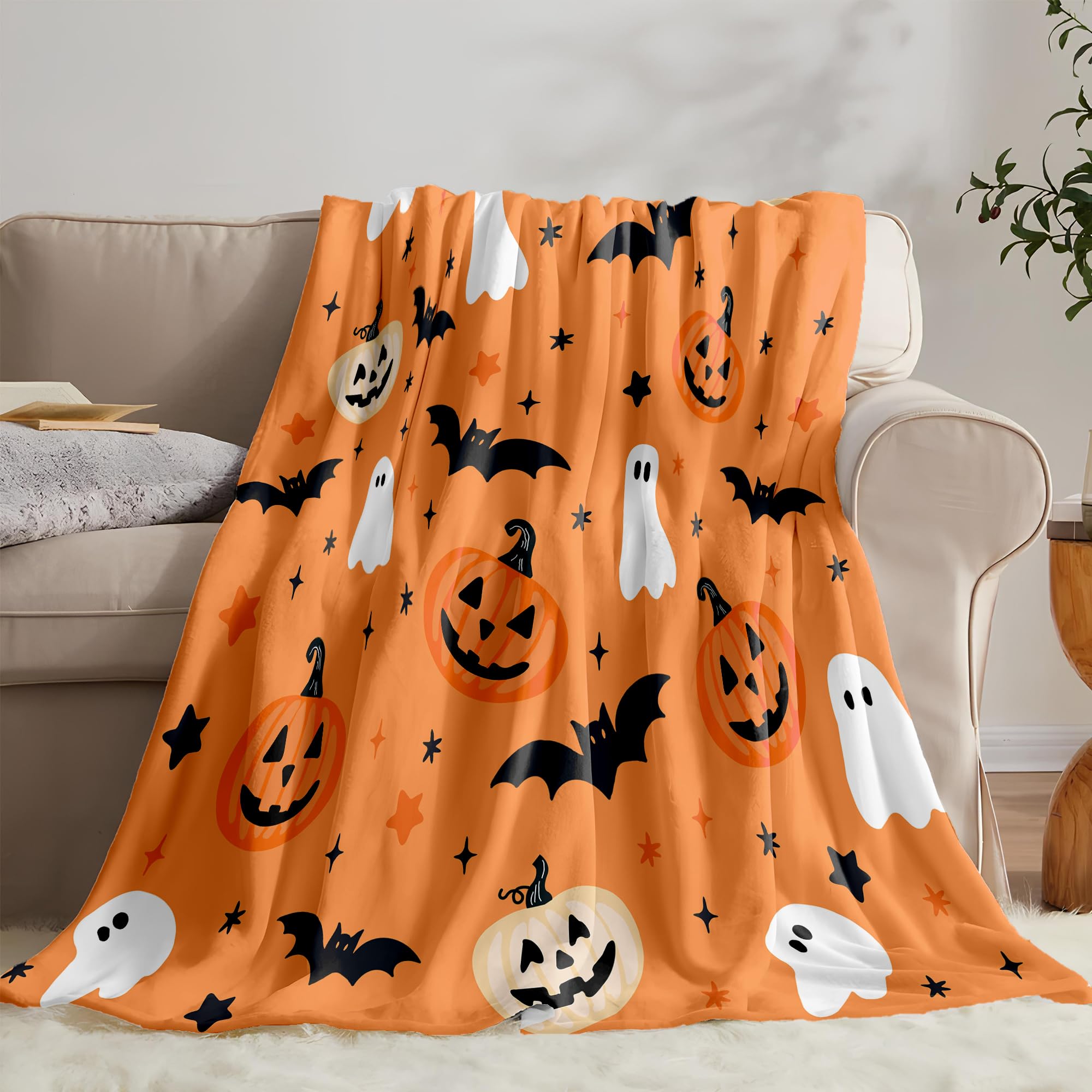 Halloween-themed blanket with pumpkins, ghosts, and bats draped over a couch.