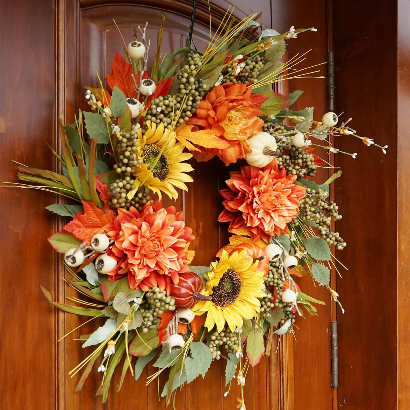 Colorful autumn wreath with flowers and berries on a wooden door
