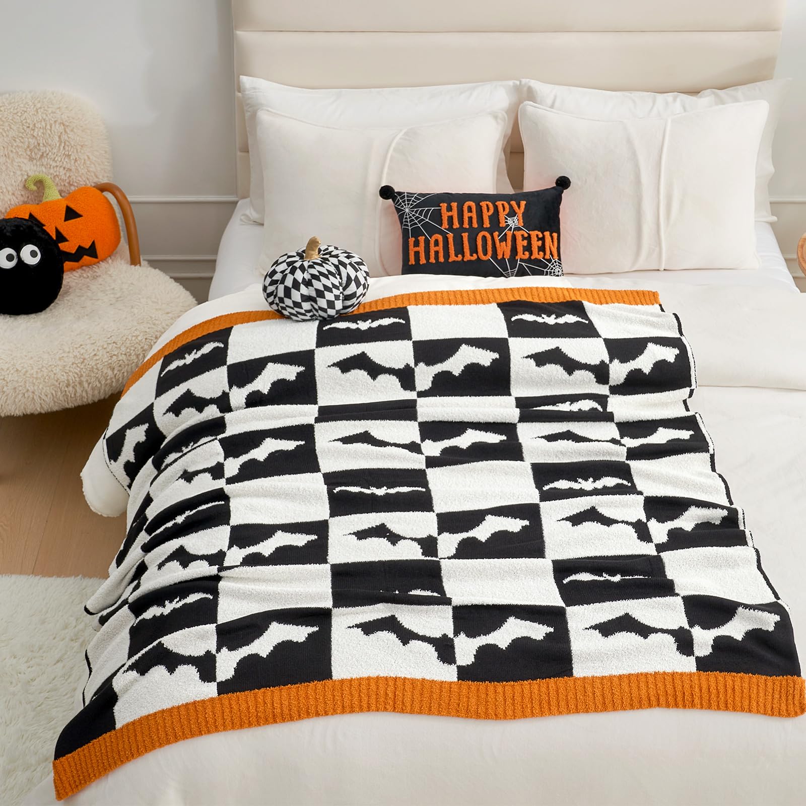 Halloween checkered blanket with bats draped over a bed, featuring Halloween decorations and pillows.