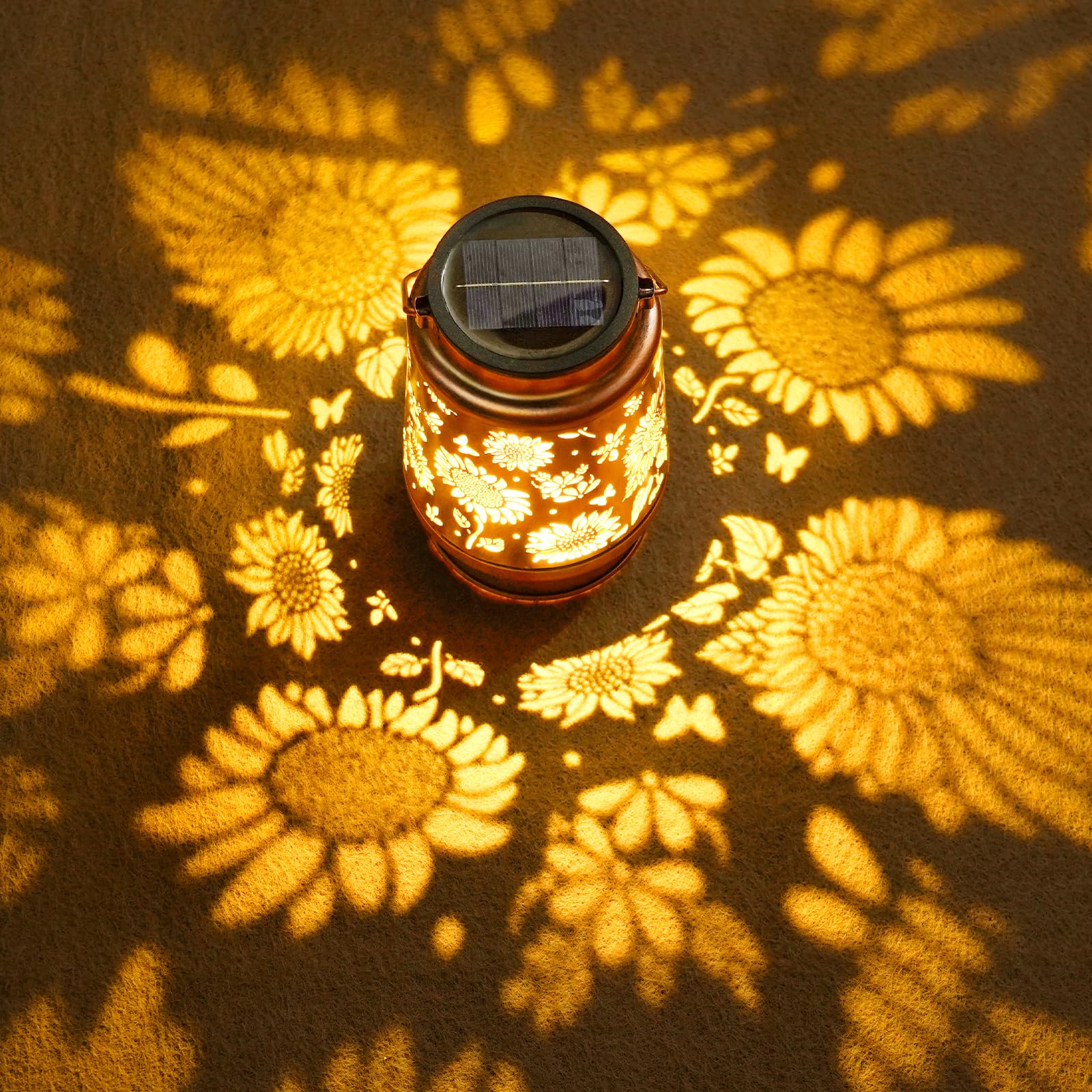 Solar lantern casting floral patterns on a dark surface
