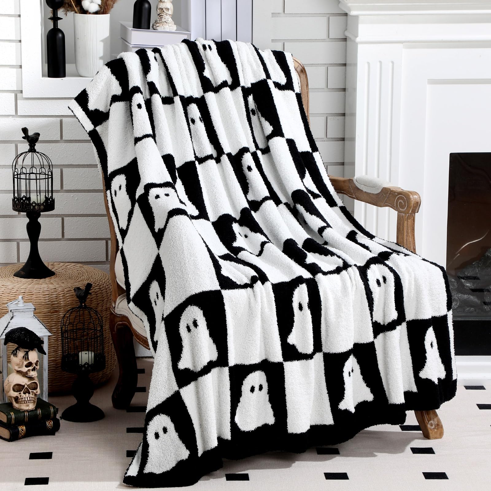 Black and white ghost patterned blanket draped over a chair in a room with Halloween decorations.