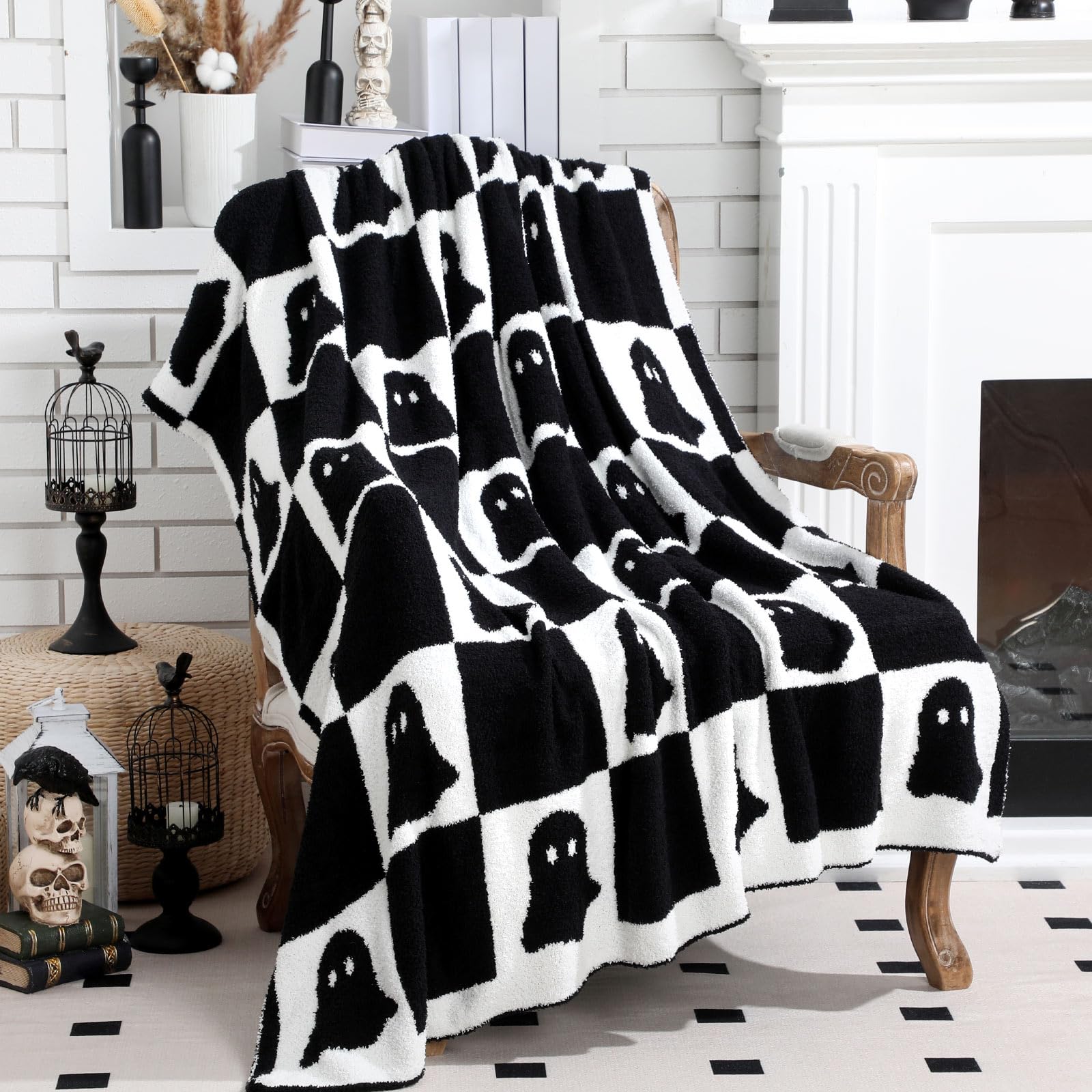 Black and white ghost patterned blanket draped over a chair in a room with decorative Halloween items.
