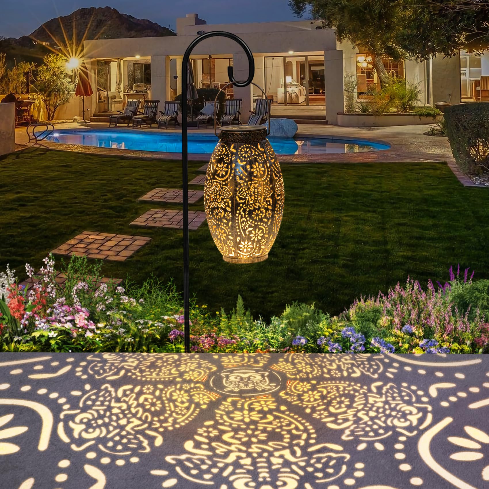Decorative outdoor light fixture casting a pattern on the ground with a pool and house in the background.
