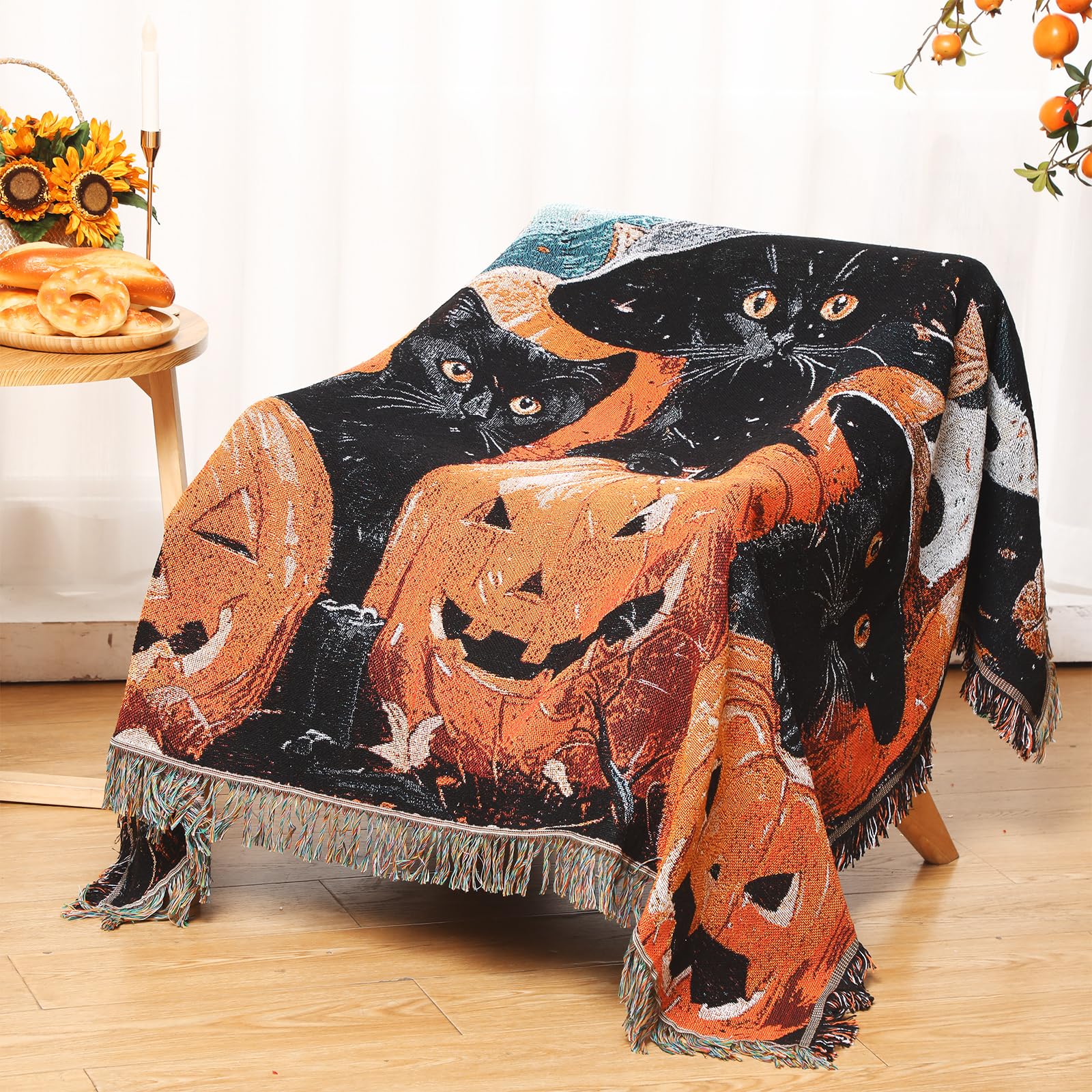 Halloween blanket with cats and pumpkins design draped over a chair.
