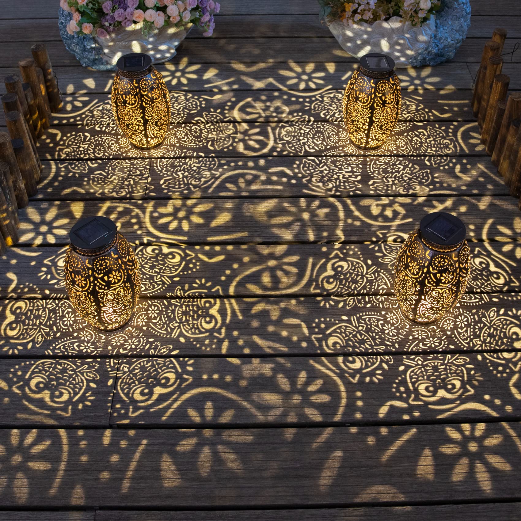 Decorative lanterns with owl patterned shadows on a wooden deck