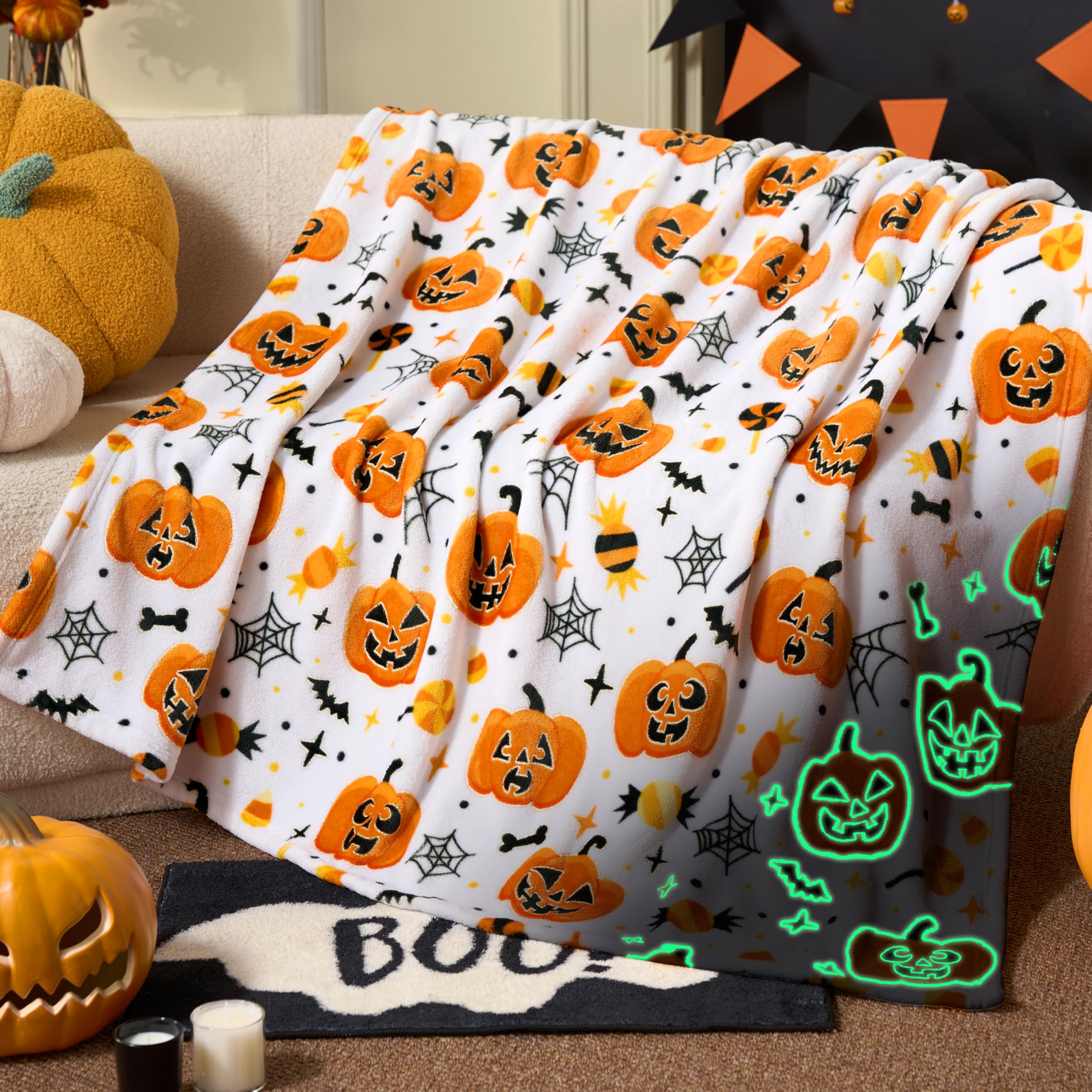 Halloween-themed blanket with pumpkins and ghosts on a couch.