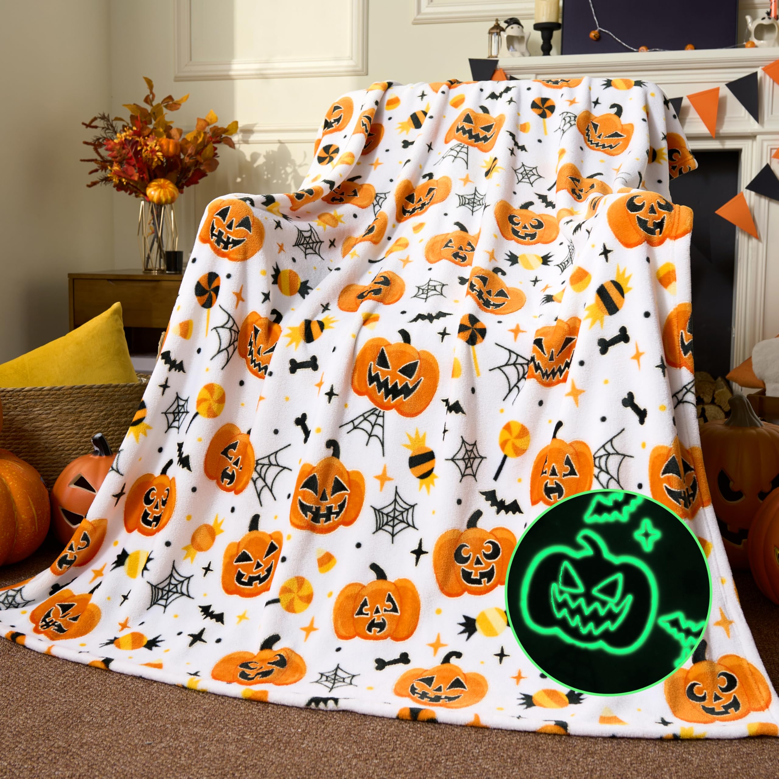 Halloween-themed blanket with pumpkins and a glowing jack-o'-lantern design on a couch.